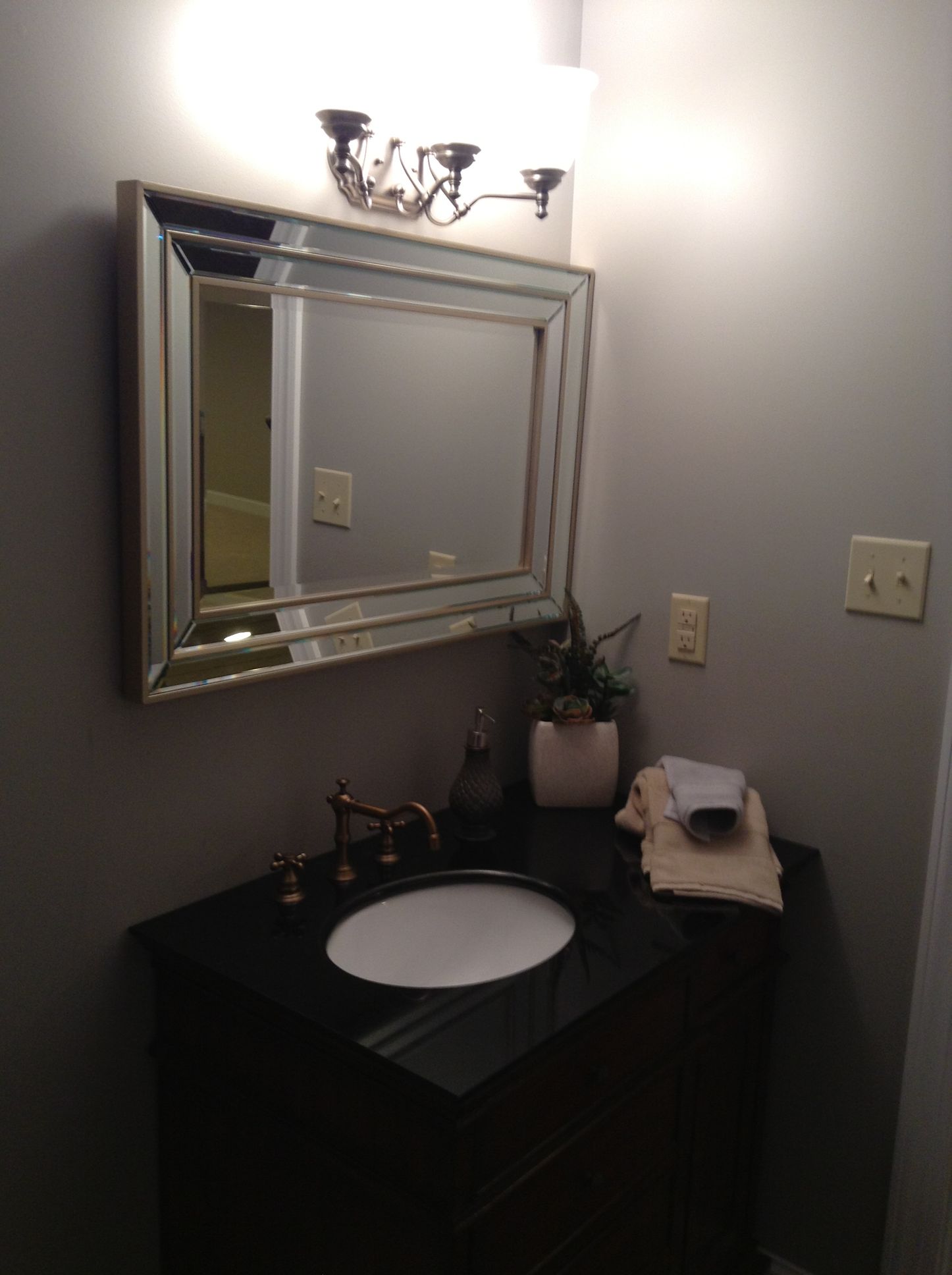 A bathroom with a sink and a mirror above it