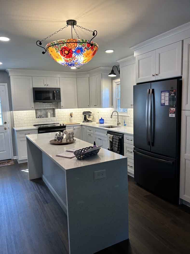 A kitchen with a large island and a chandelier hanging from the ceiling.