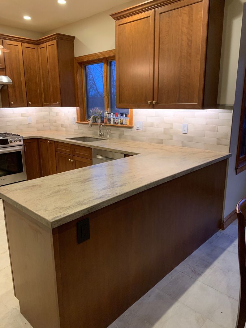A kitchen with wooden cabinets , a sink , and a stove.