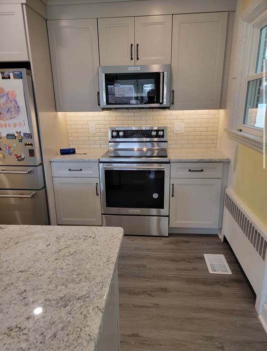A kitchen with stainless steel appliances and white cabinets.