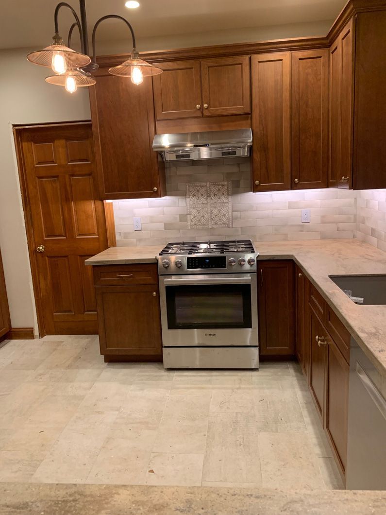 A kitchen with stainless steel appliances and wooden cabinets.