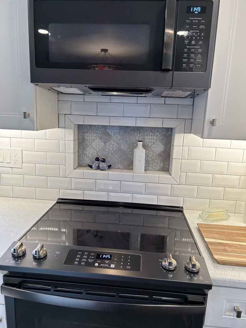A black stove top oven with a microwave above it in a kitchen.