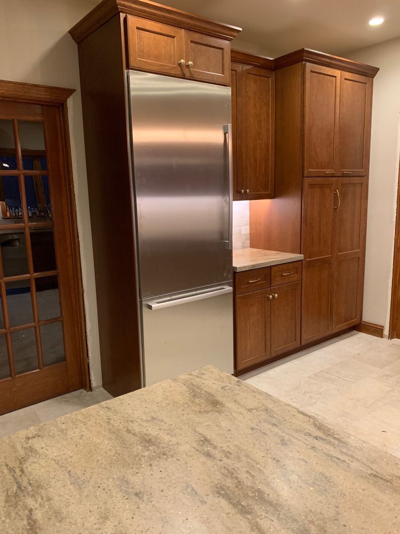 A kitchen with stainless steel appliances and wooden cabinets.