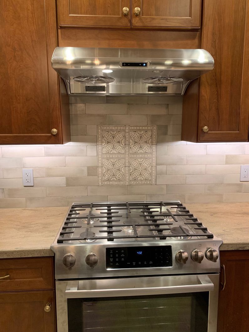 A stove top oven is sitting on top of a wooden counter in a kitchen.