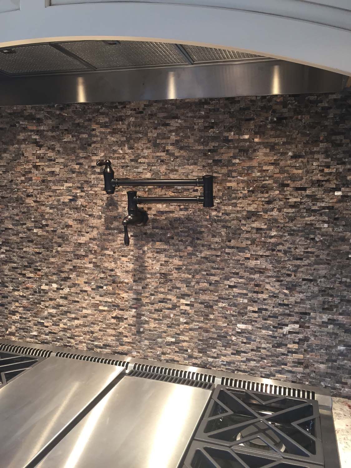 A kitchen with a stove top oven and a faucet