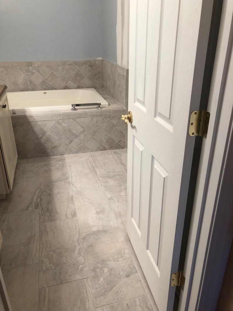A bathroom with a tub and a door leading to it.