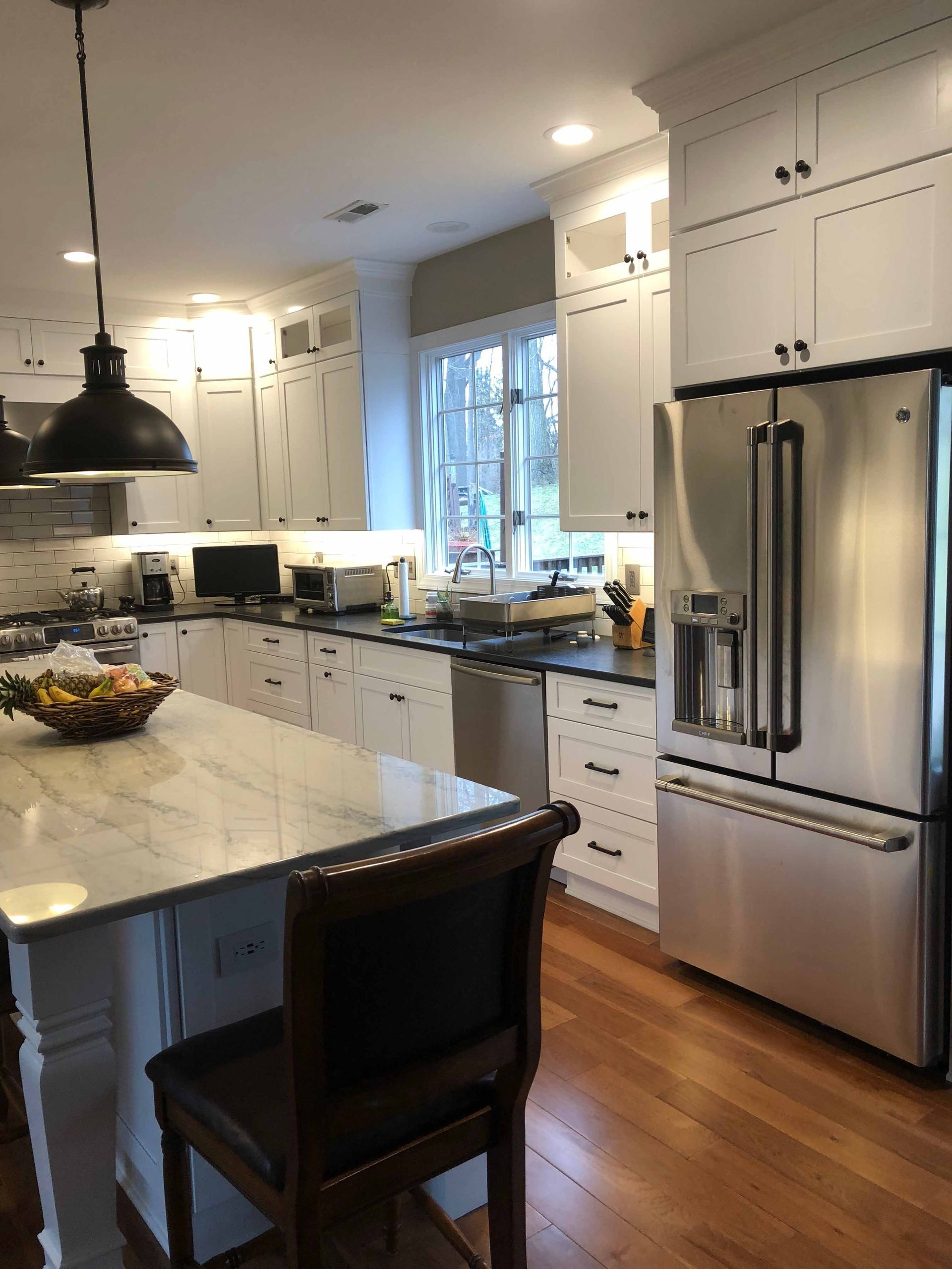 A kitchen with stainless steel appliances and white cabinets