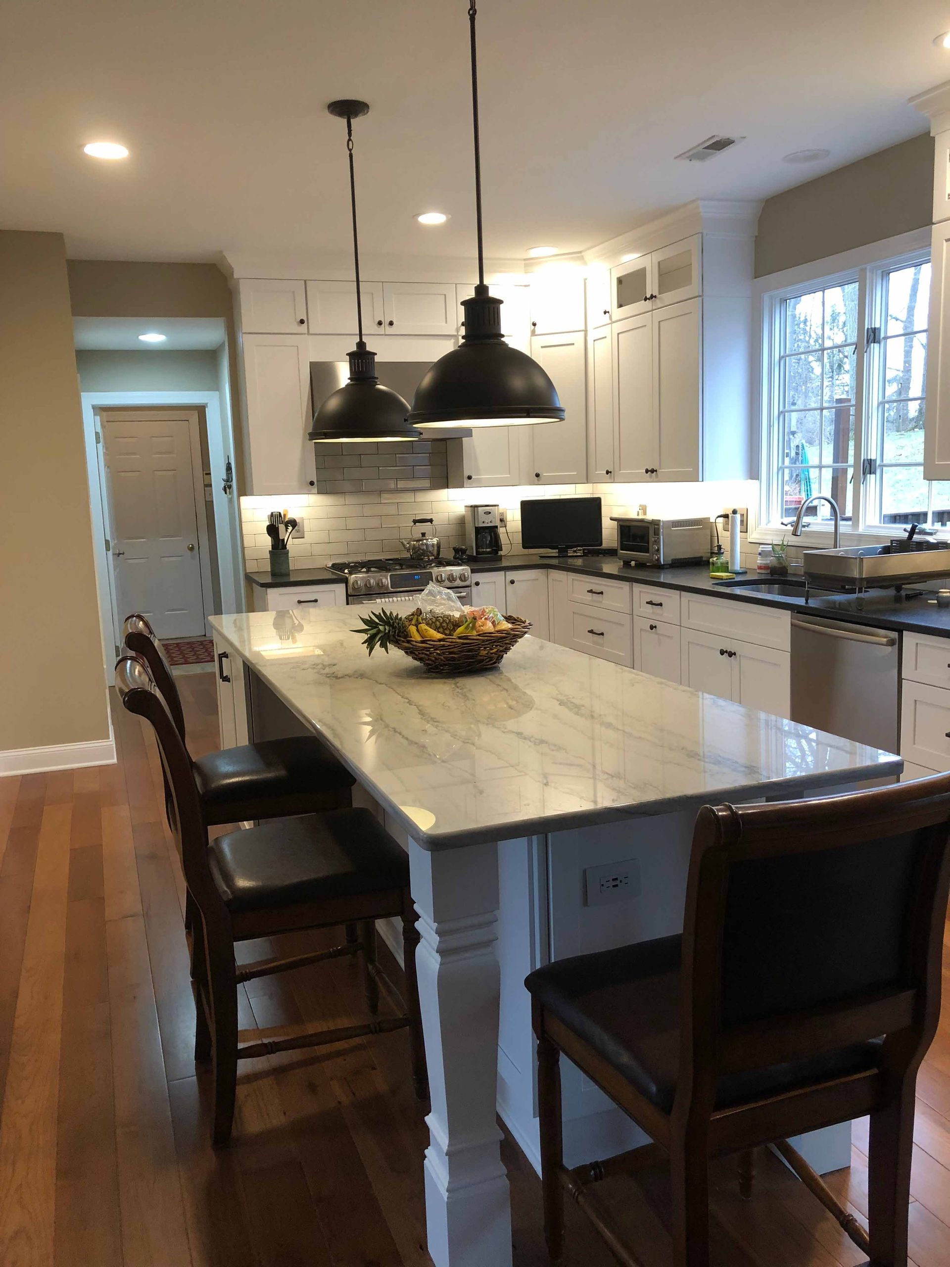 A kitchen with a large island and chairs