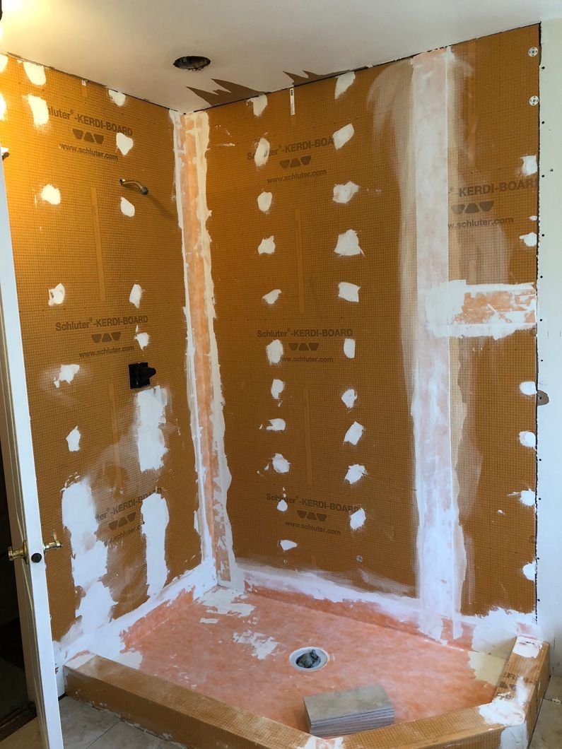 A shower stall is being built in a bathroom.