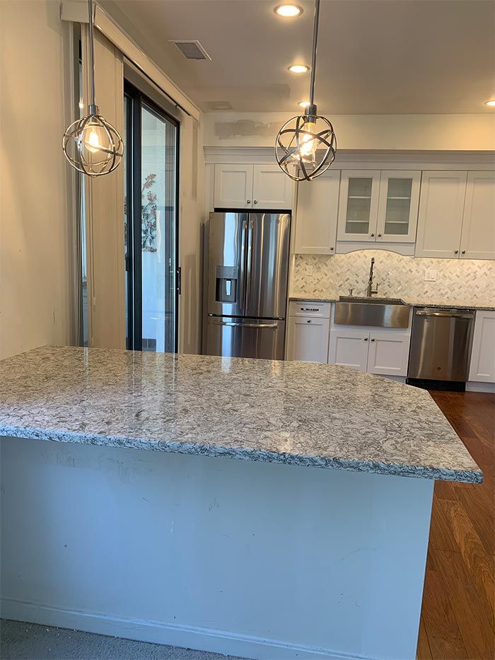 A kitchen with stainless steel appliances and granite counter tops.