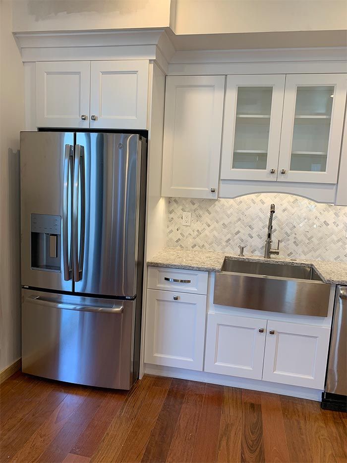 A kitchen with stainless steel appliances and white cabinets