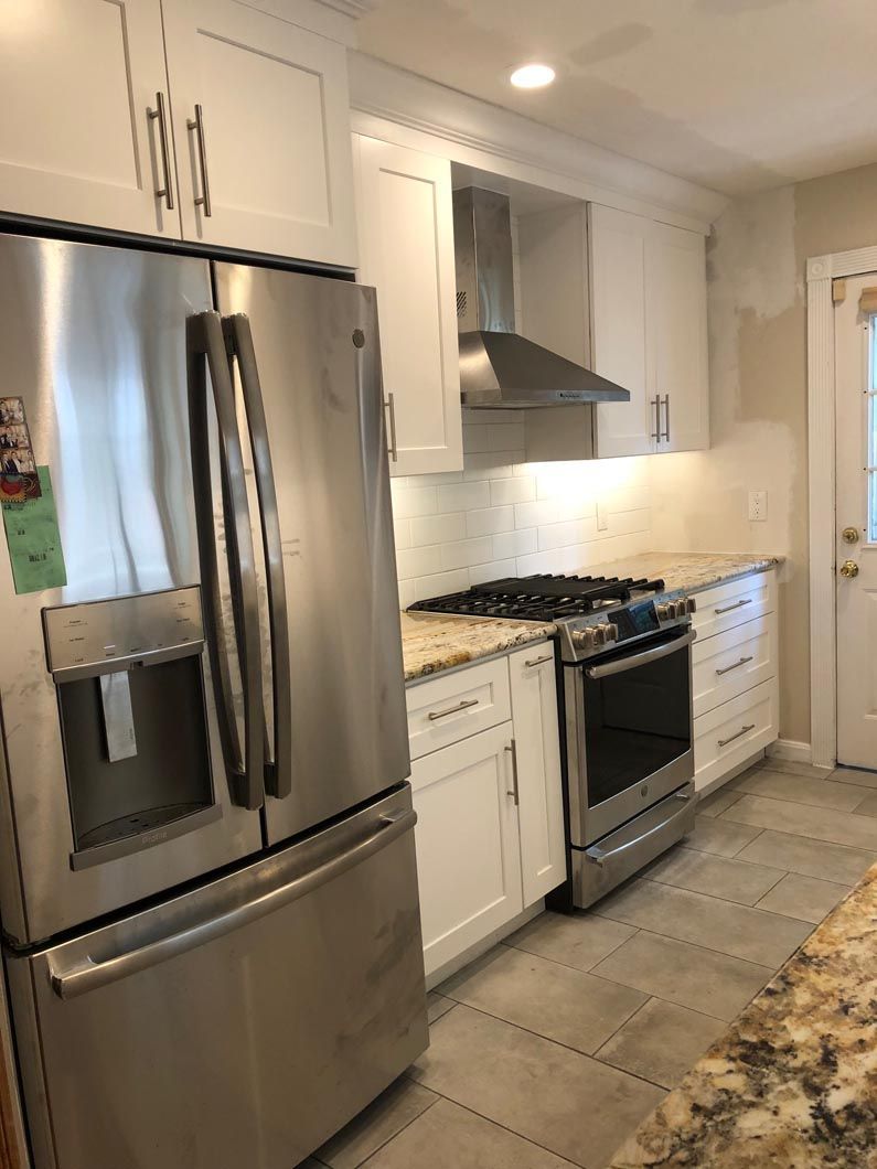 A kitchen with stainless steel appliances and white cabinets.