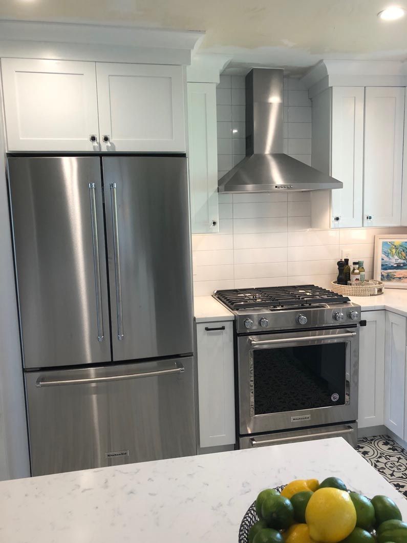 A kitchen with stainless steel appliances and white cabinets