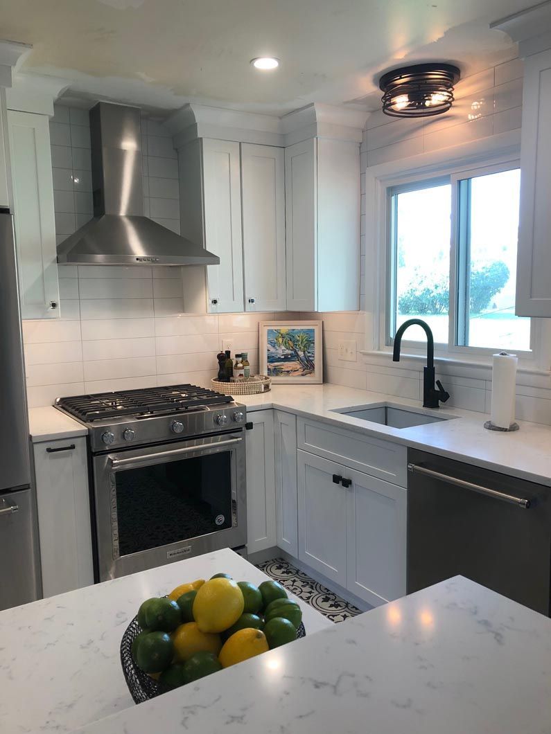 A kitchen with a bowl of lemons and limes on the counter.