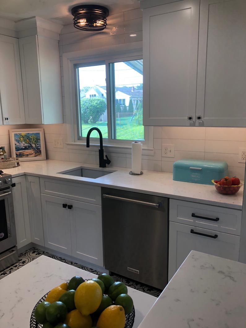A kitchen with a bowl of lemons and limes on the counter