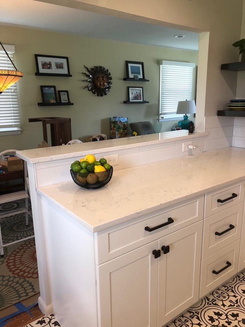 A kitchen counter with a bowl of lemons and limes on it.