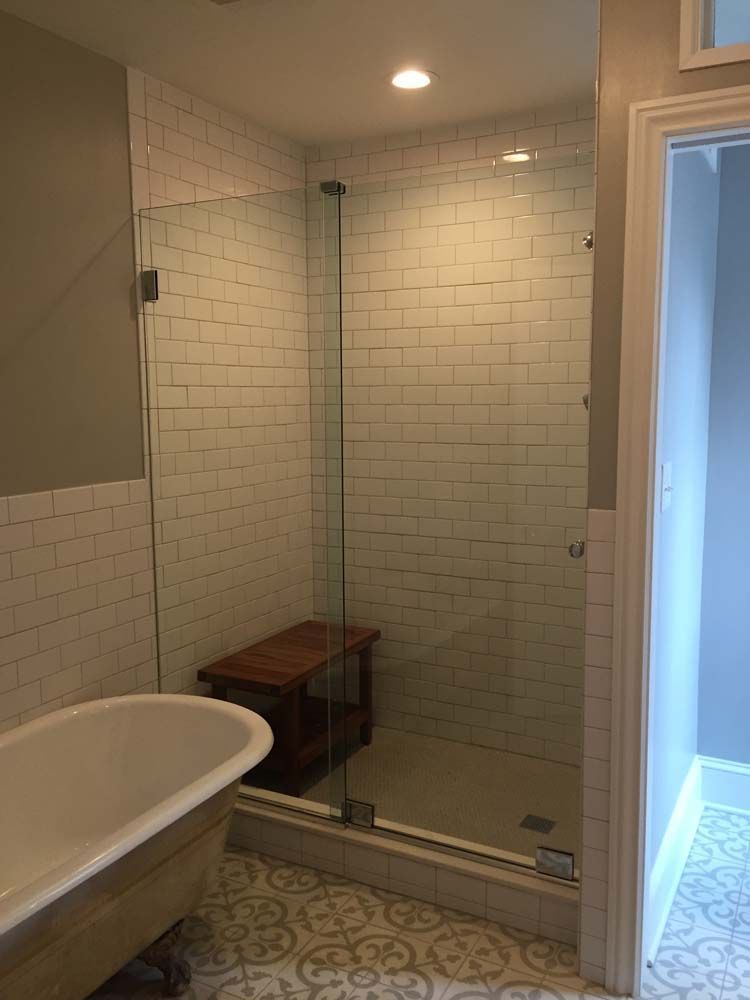 A bathroom with a bathtub and a walk in shower with a glass door.