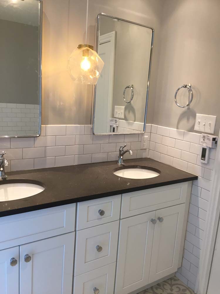 A bathroom with two sinks and a mirror.