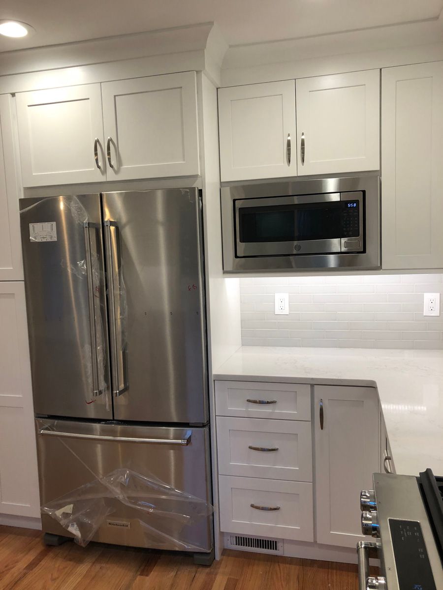 A kitchen with stainless steel appliances and white cabinets