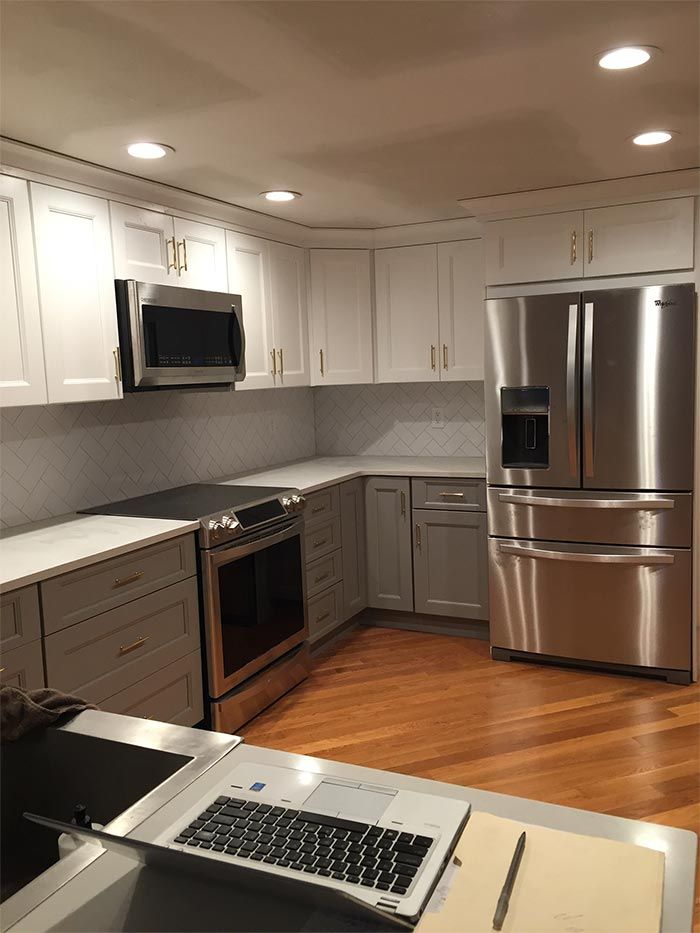 A kitchen with stainless steel appliances and white cabinets
