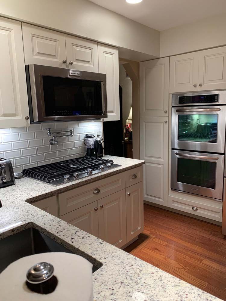 A kitchen with white cabinets and stainless steel appliances.