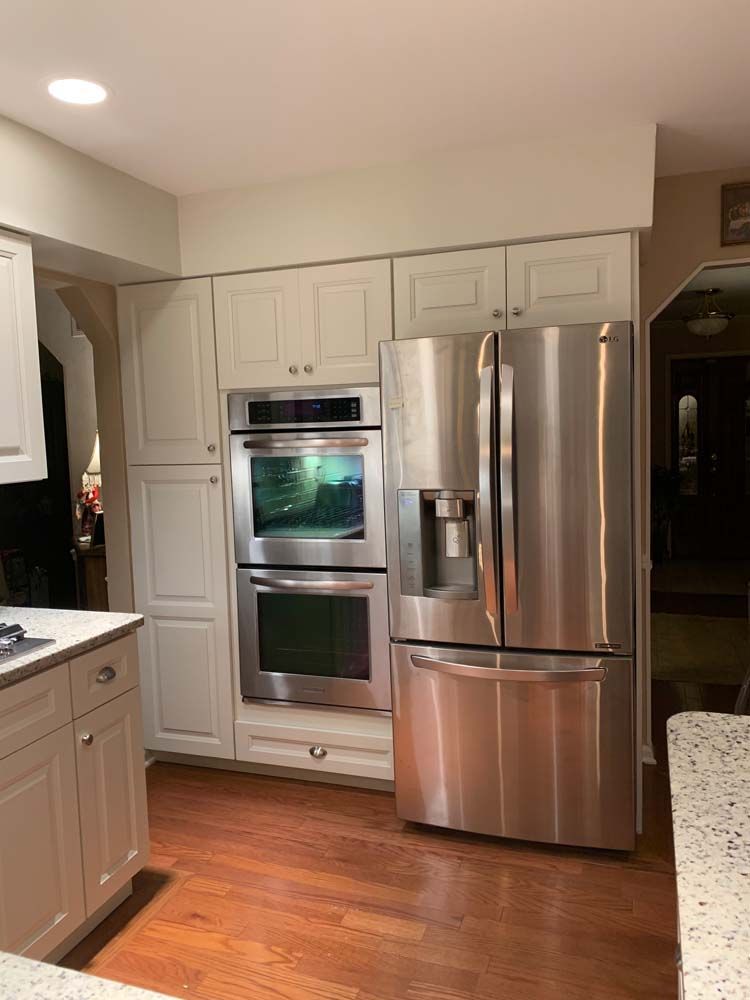 A kitchen with stainless steel appliances and white cabinets.