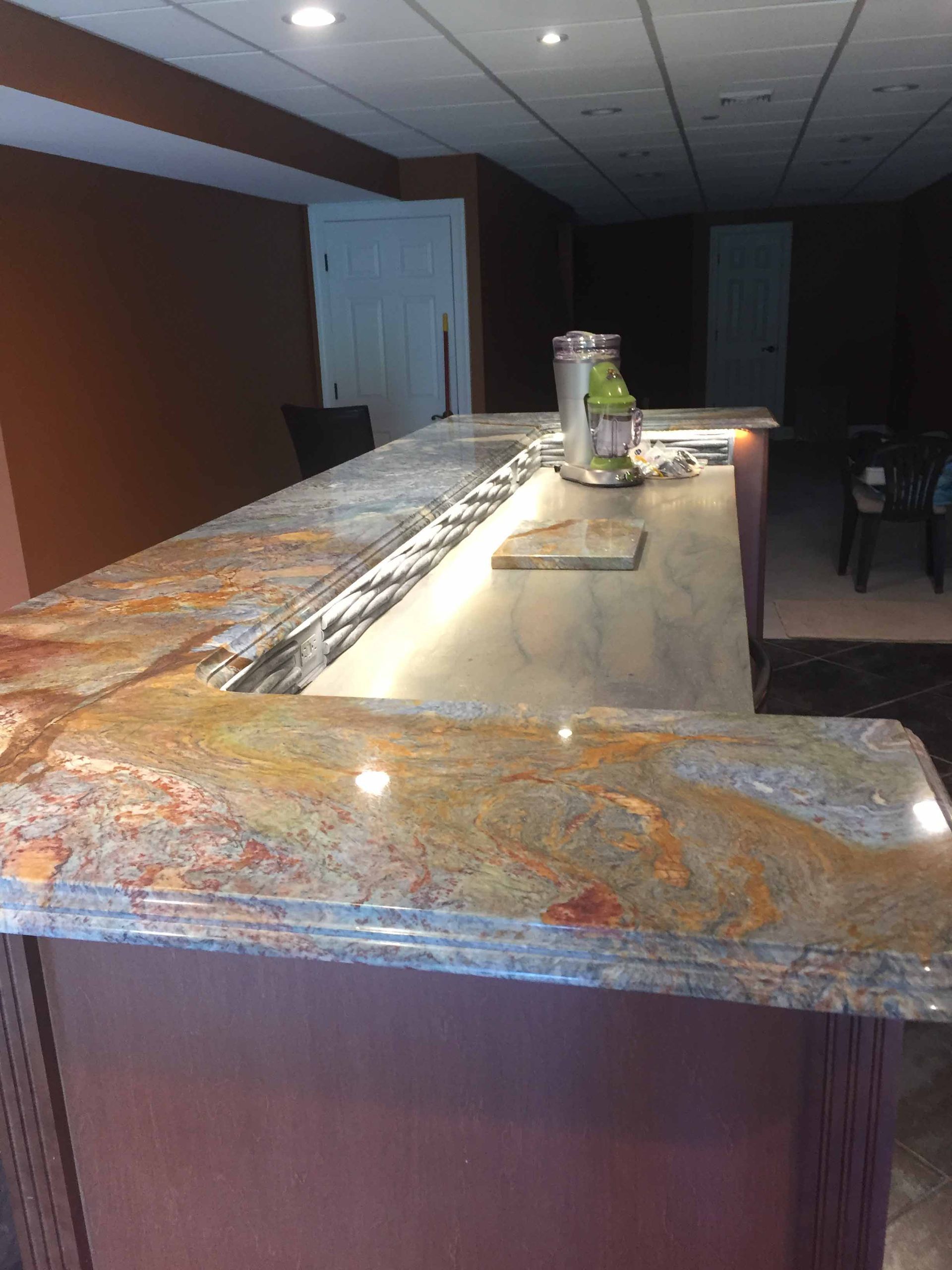 A long counter in a room with a marble counter top.