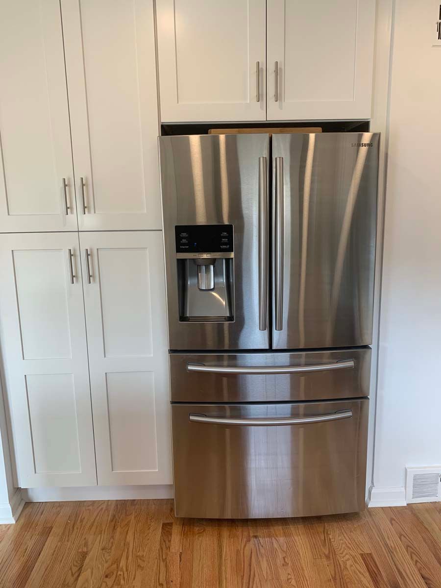 A stainless steel refrigerator with a water dispenser is in a kitchen.