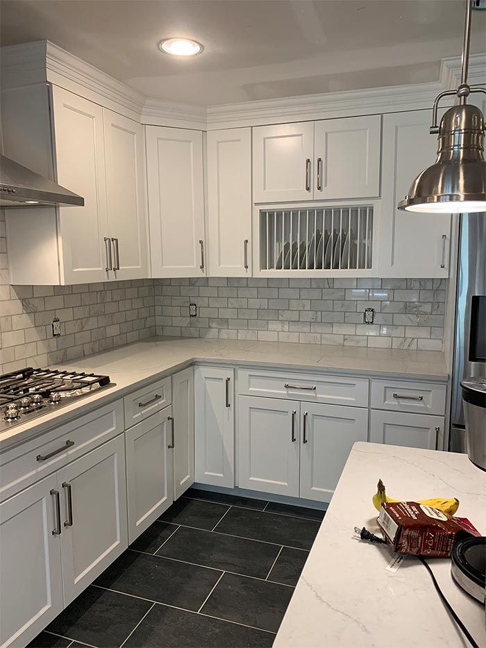 A kitchen with white cabinets and stainless steel appliances