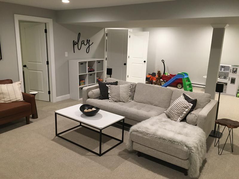 A living room with a couch and a coffee table in a basement.