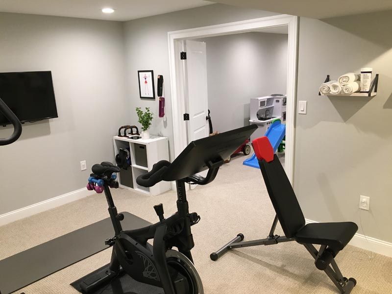 A home gym with a bicycle and a bench.