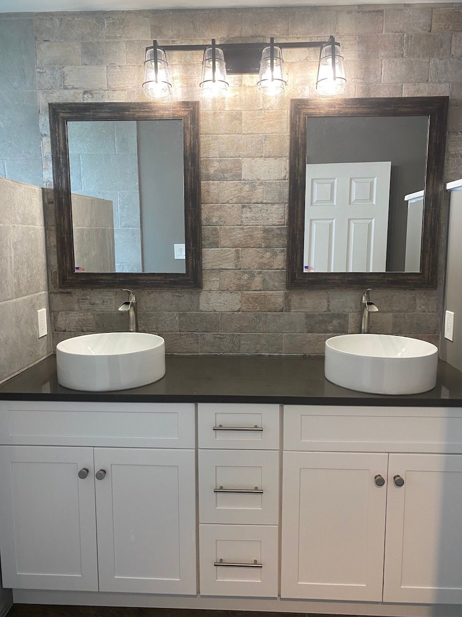 A bathroom with two sinks and two mirrors.