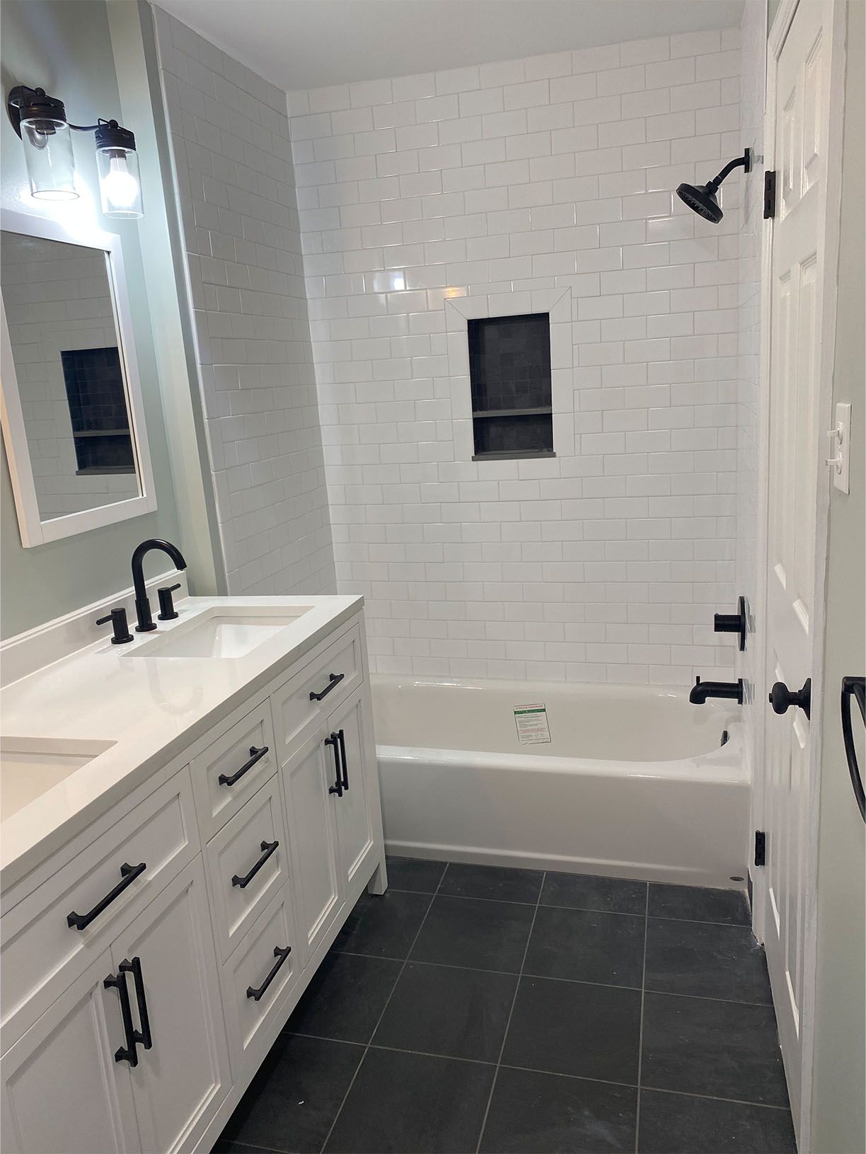 A bathroom with two sinks , a tub , and a shower.