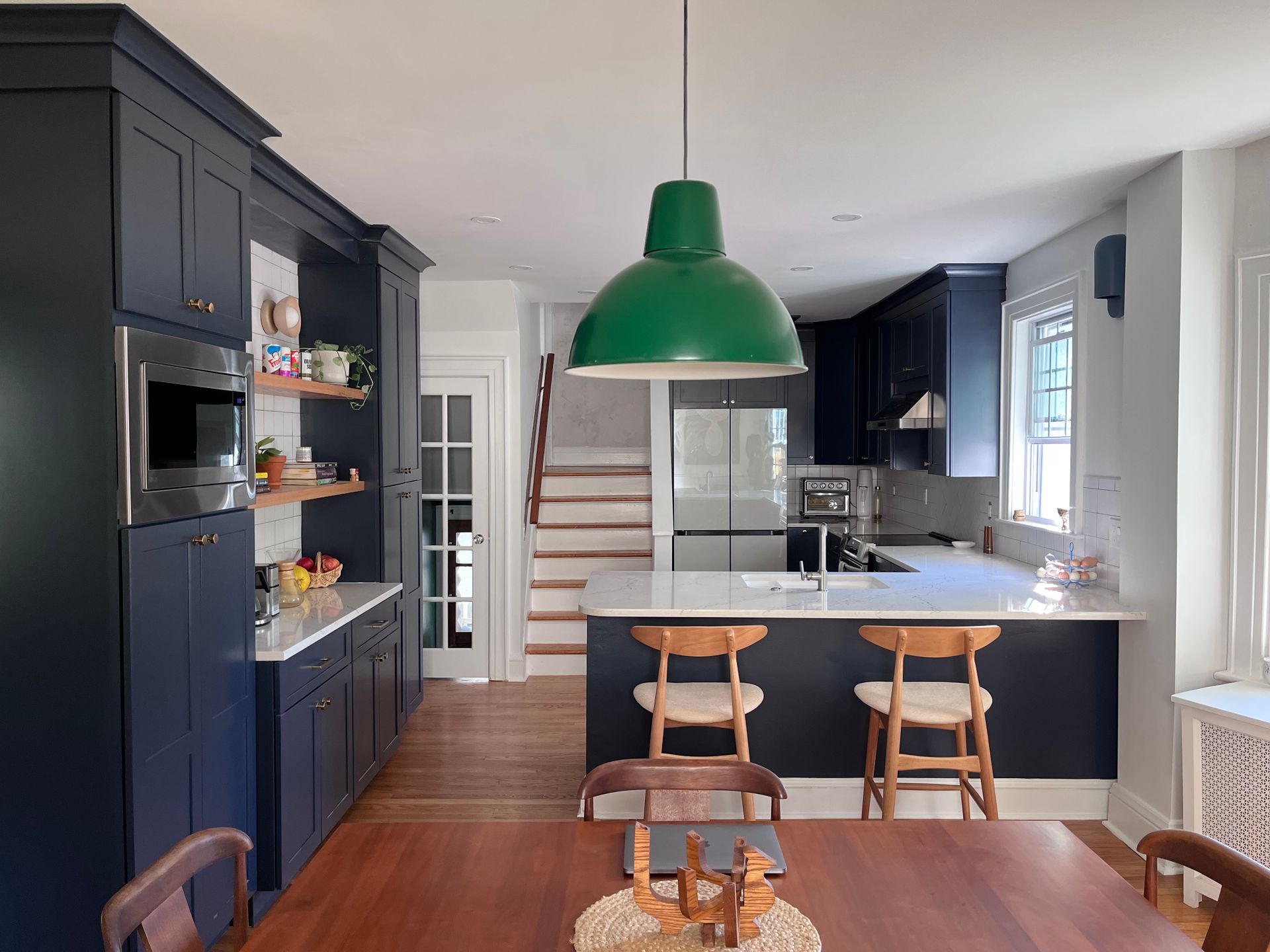 A kitchen with blue cabinets and a green light hanging from the ceiling