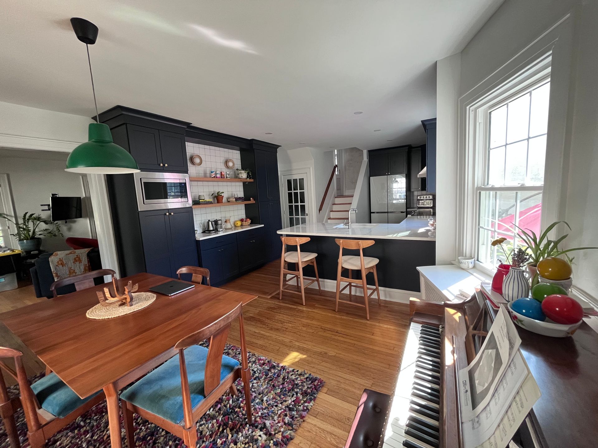 A living room with a dining table and chairs and a piano.