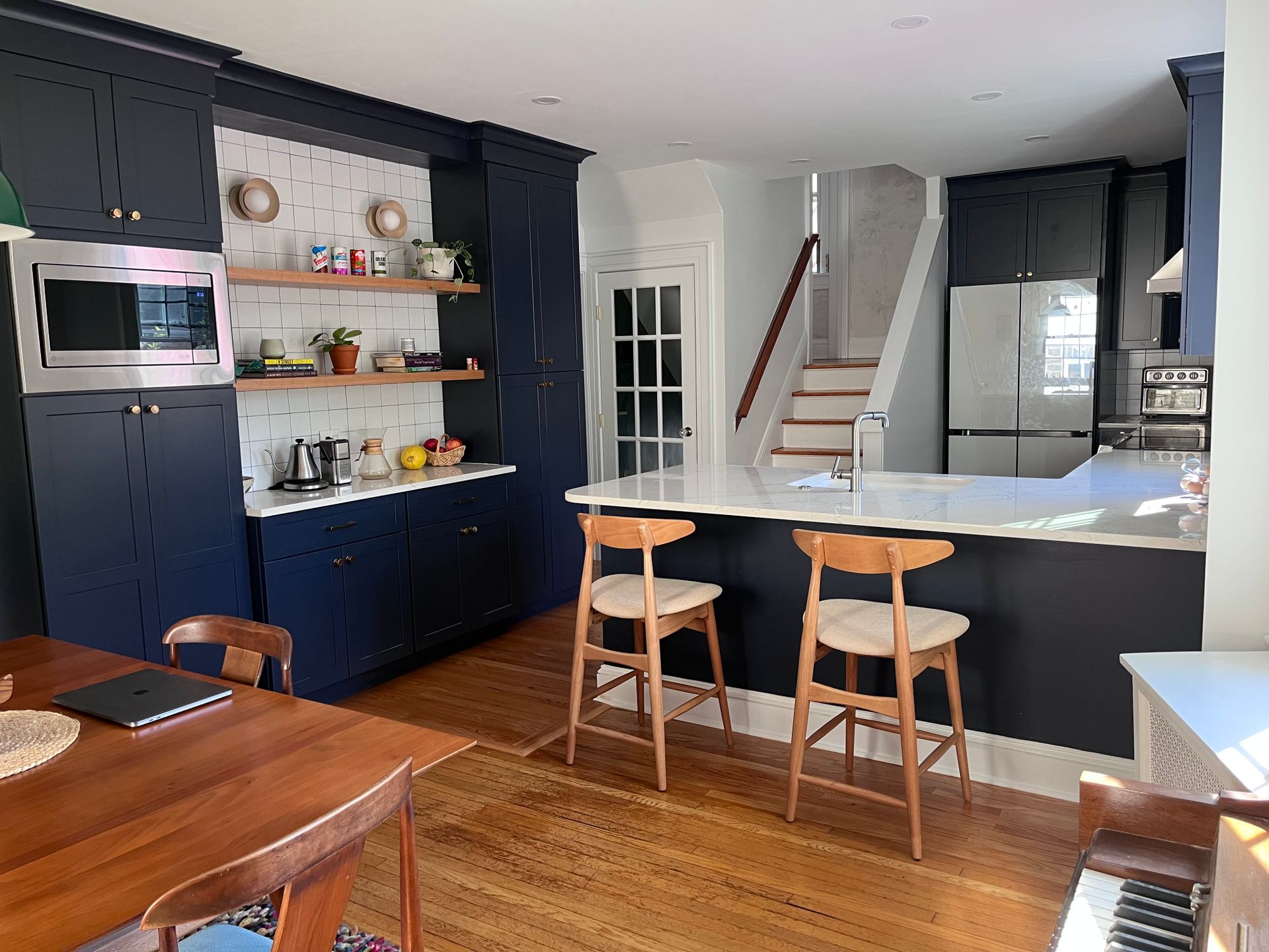 A kitchen with blue cabinets and white counter tops