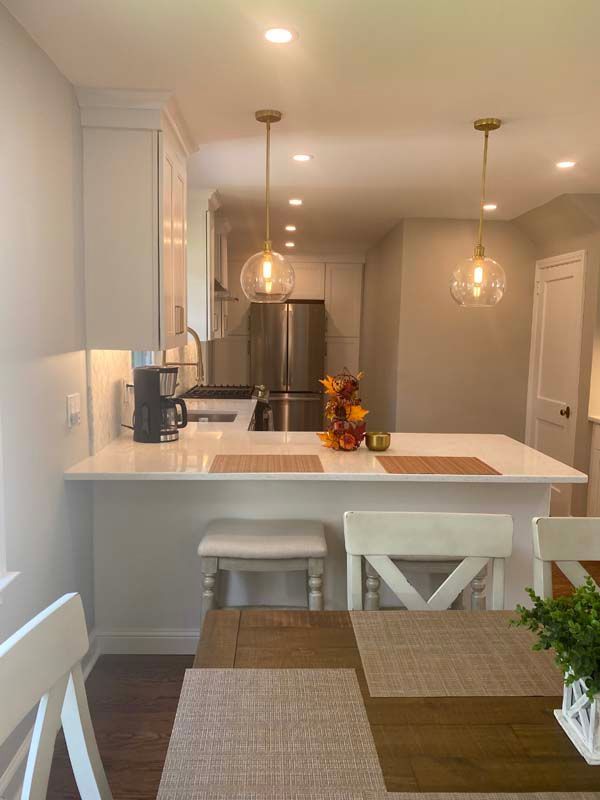 A kitchen with a table and chairs and a refrigerator.