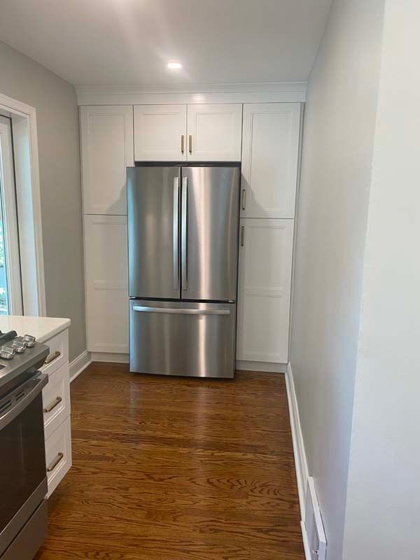 There is a stainless steel refrigerator in the middle of the kitchen.