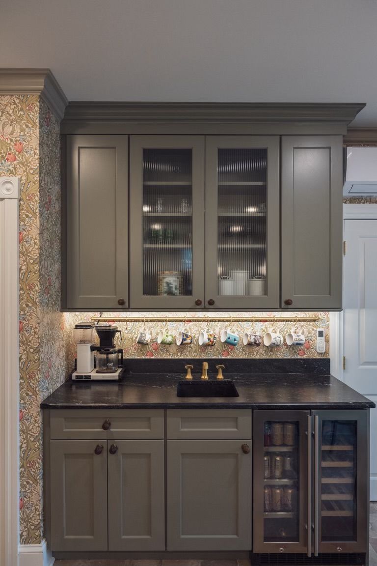 A kitchen with gray cabinets , a sink , a refrigerator and a coffee maker.