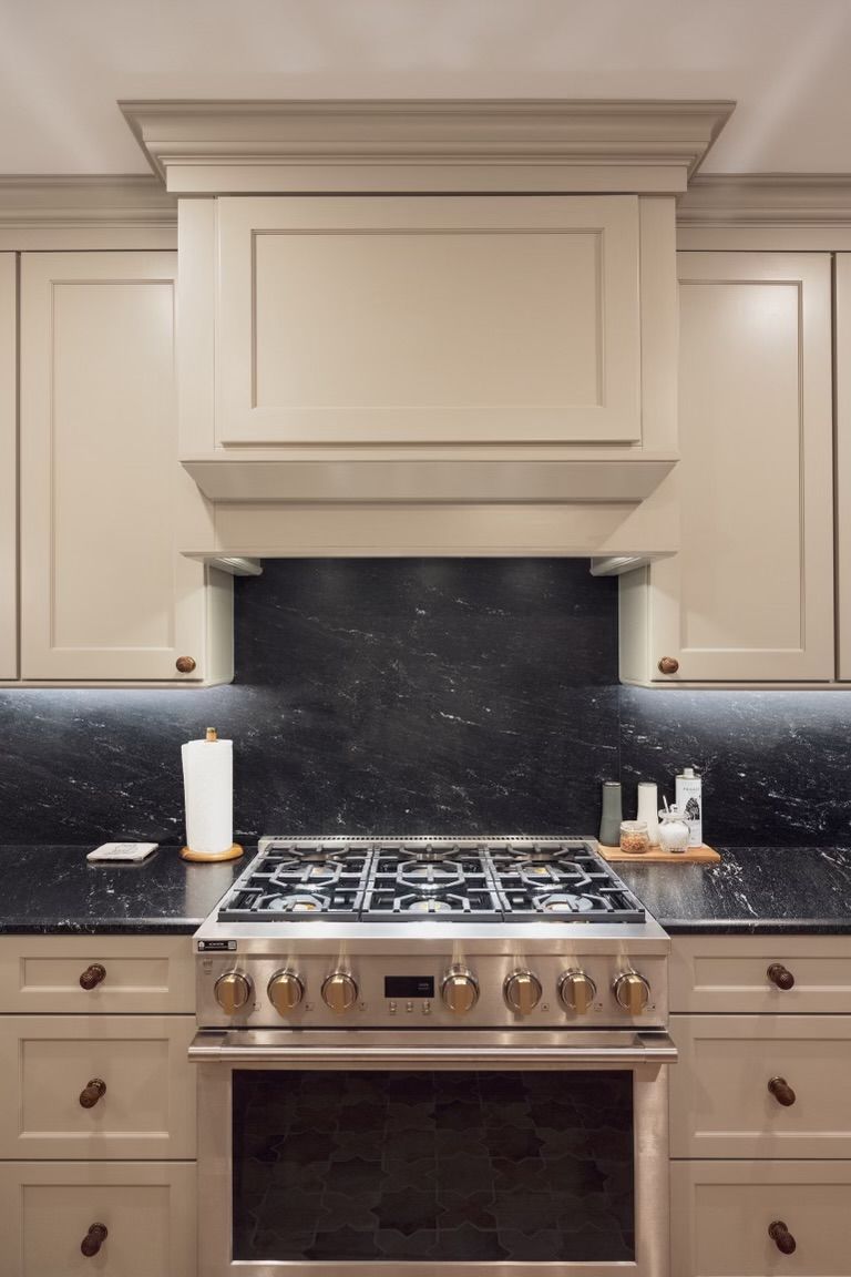 A kitchen with white cabinets and a stove top oven