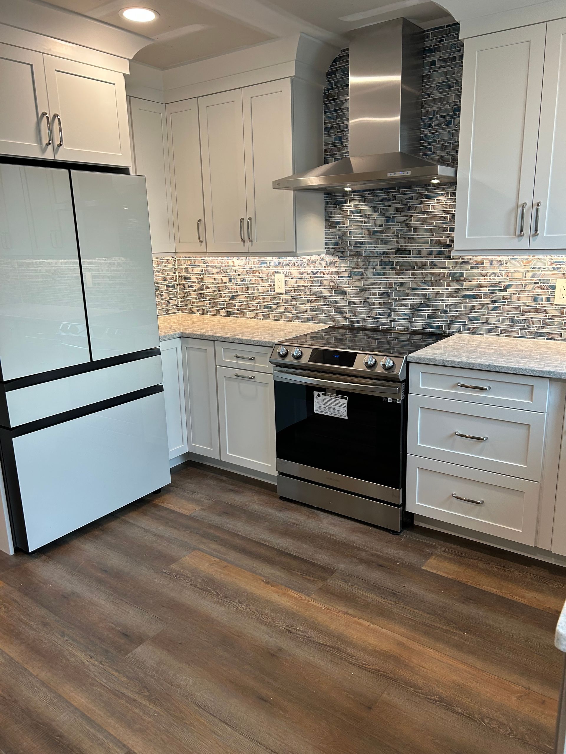 A kitchen with stainless steel appliances and white cabinets