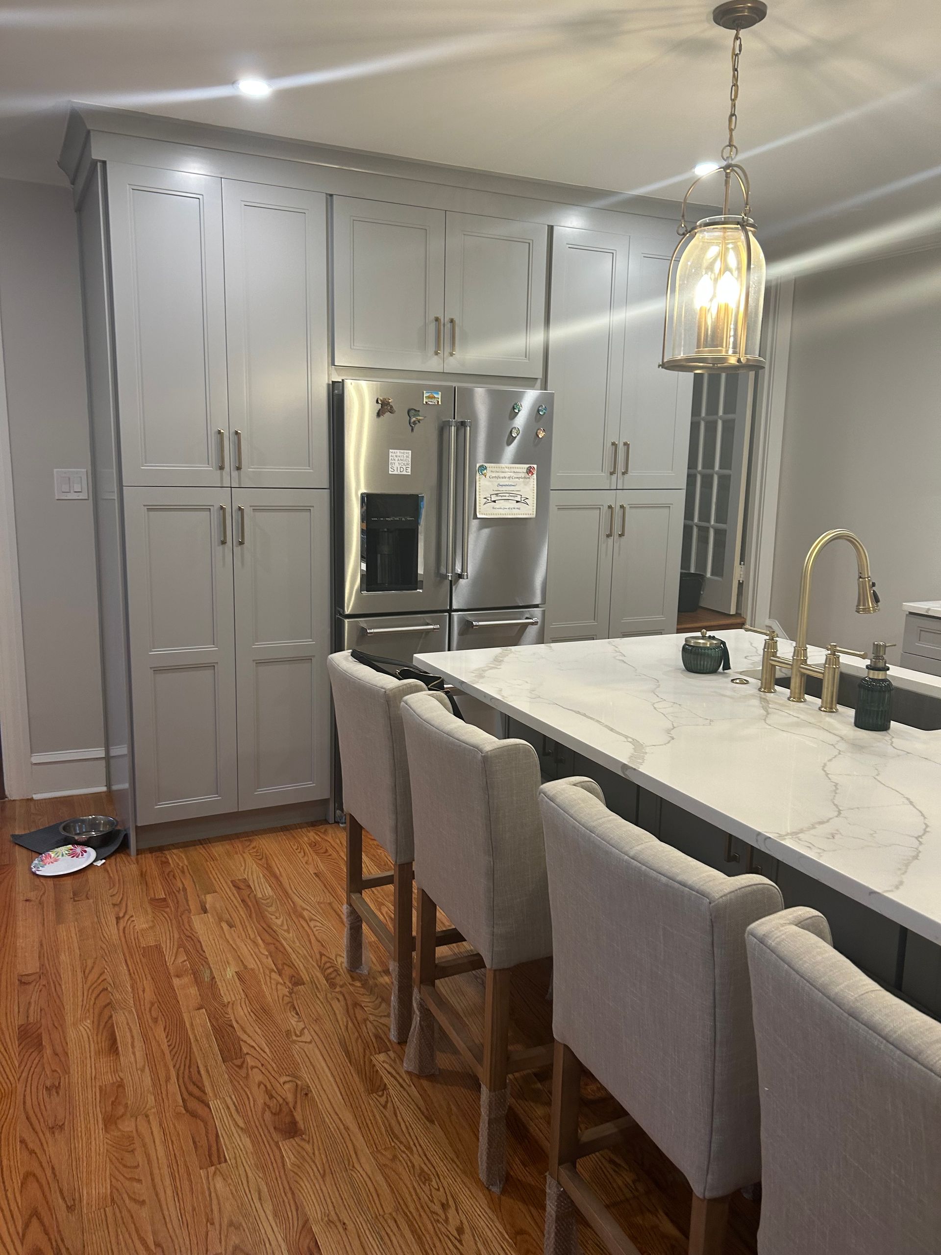 A kitchen with a stainless steel refrigerator , sink , and cabinets.