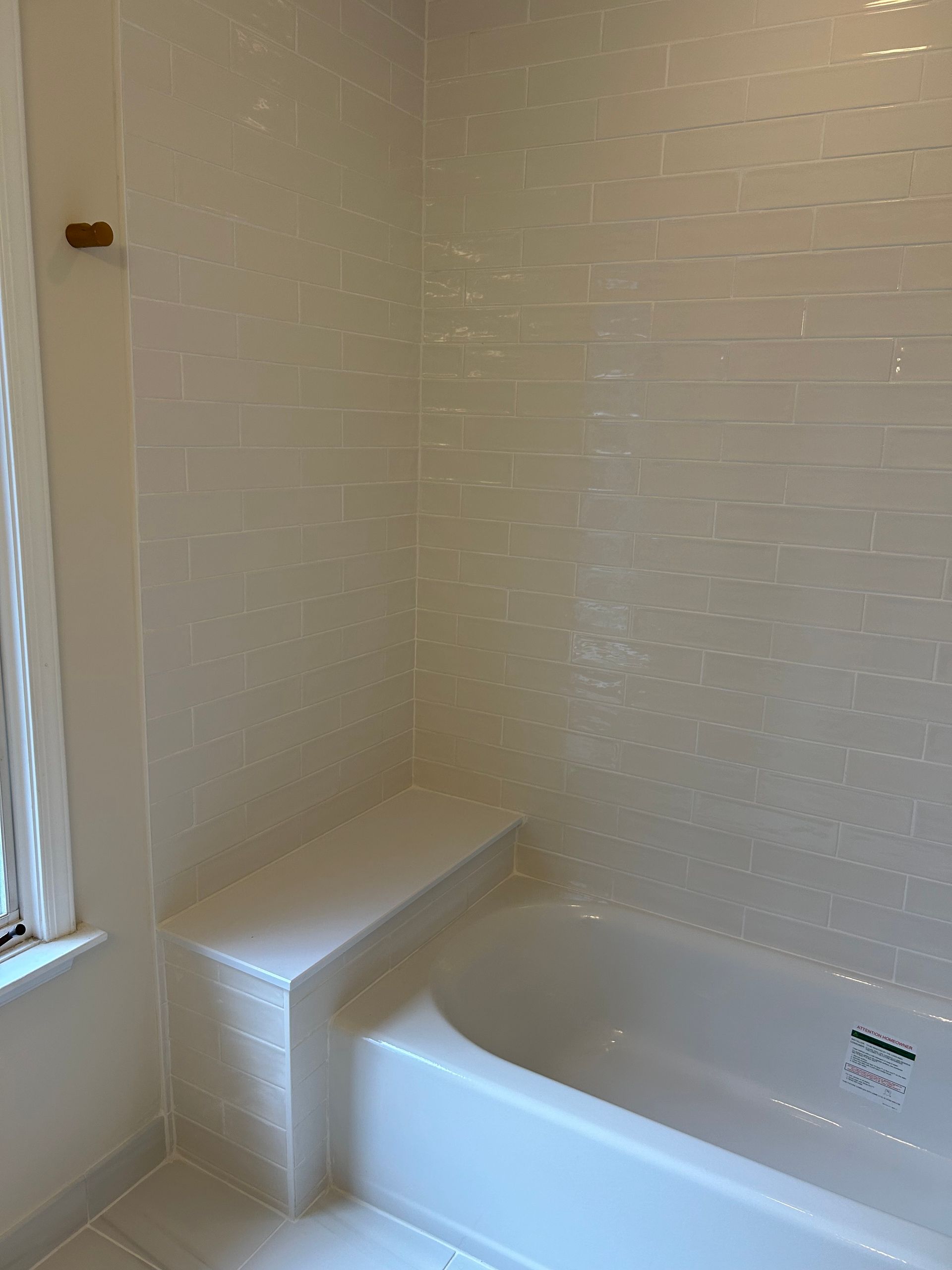 A bathroom with a bathtub and a window.