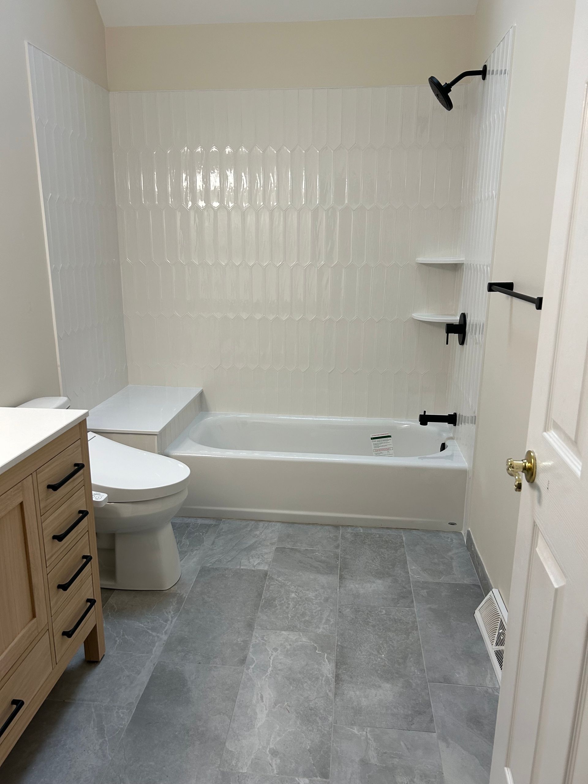 A bathroom with a toilet a bathtub and a shower