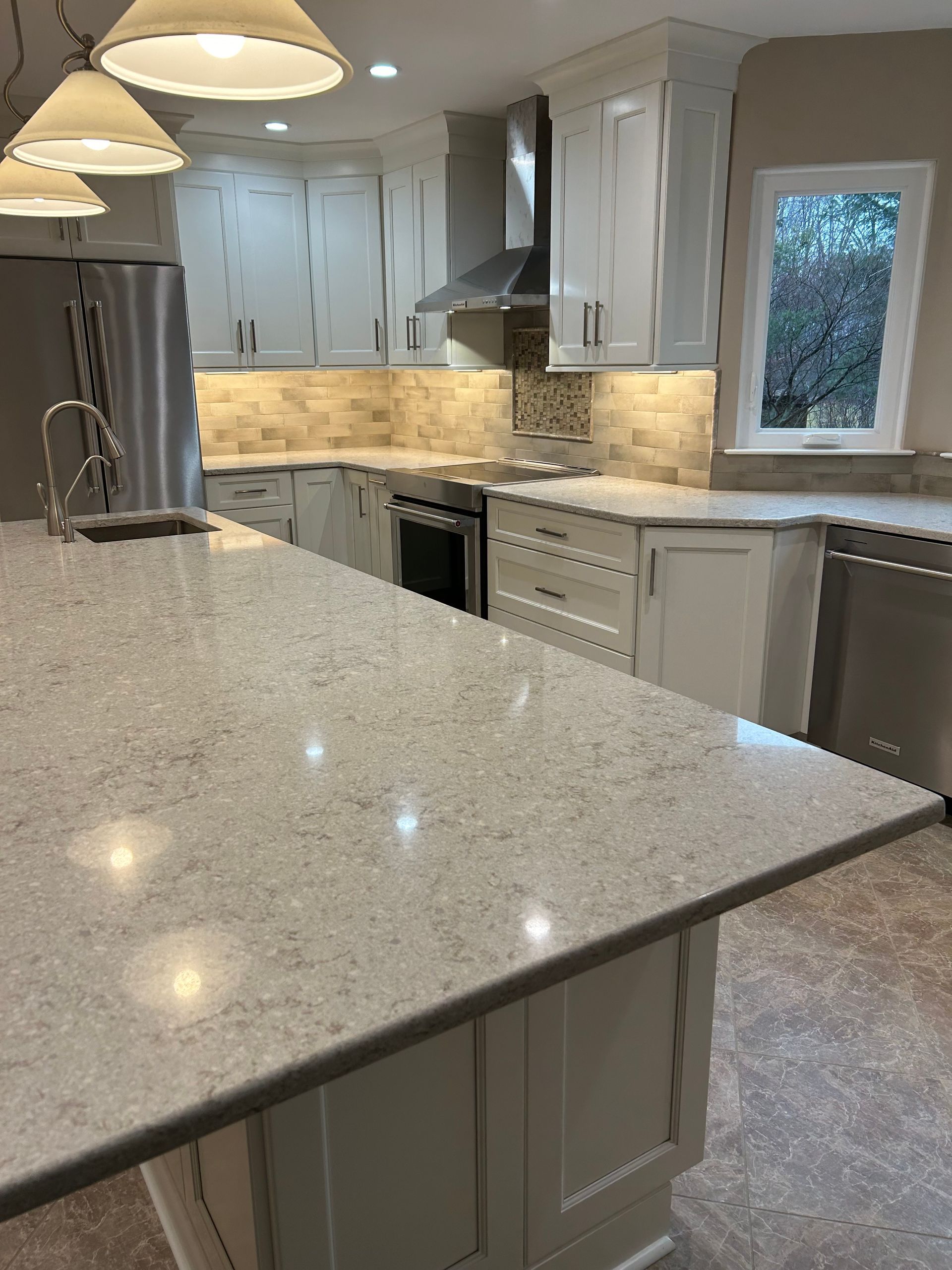 A kitchen with white cabinets and granite counter tops