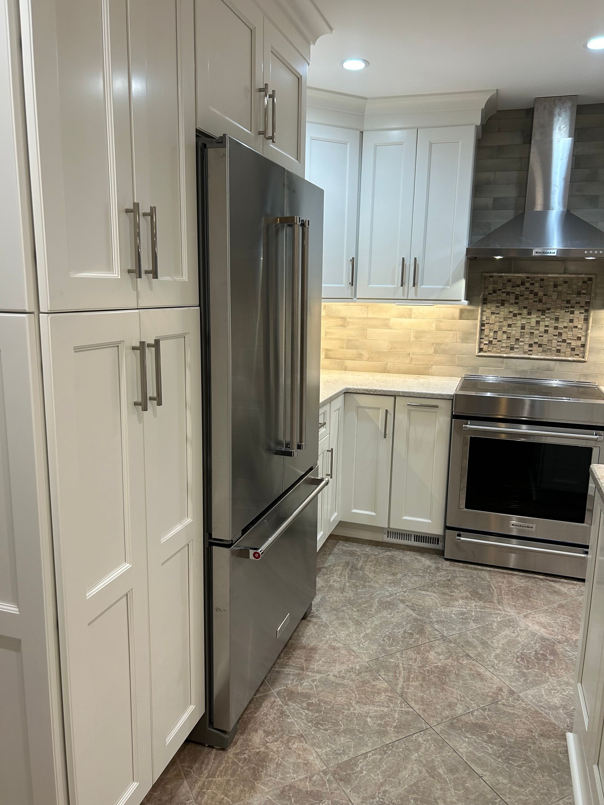 A kitchen with white cabinets and stainless steel appliances.