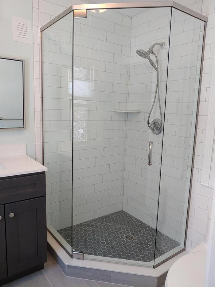 A bathroom with a shower stall and a sink.