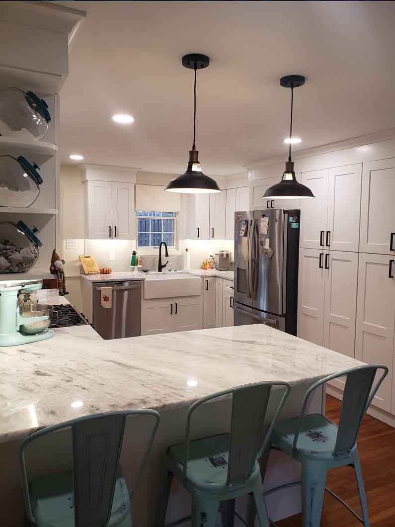 A kitchen with a marble counter top and stainless steel appliances