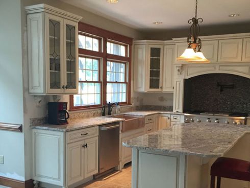 A kitchen with white cabinets and granite counter tops