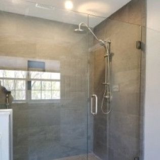 A bathroom with a glass shower door and a shower head.